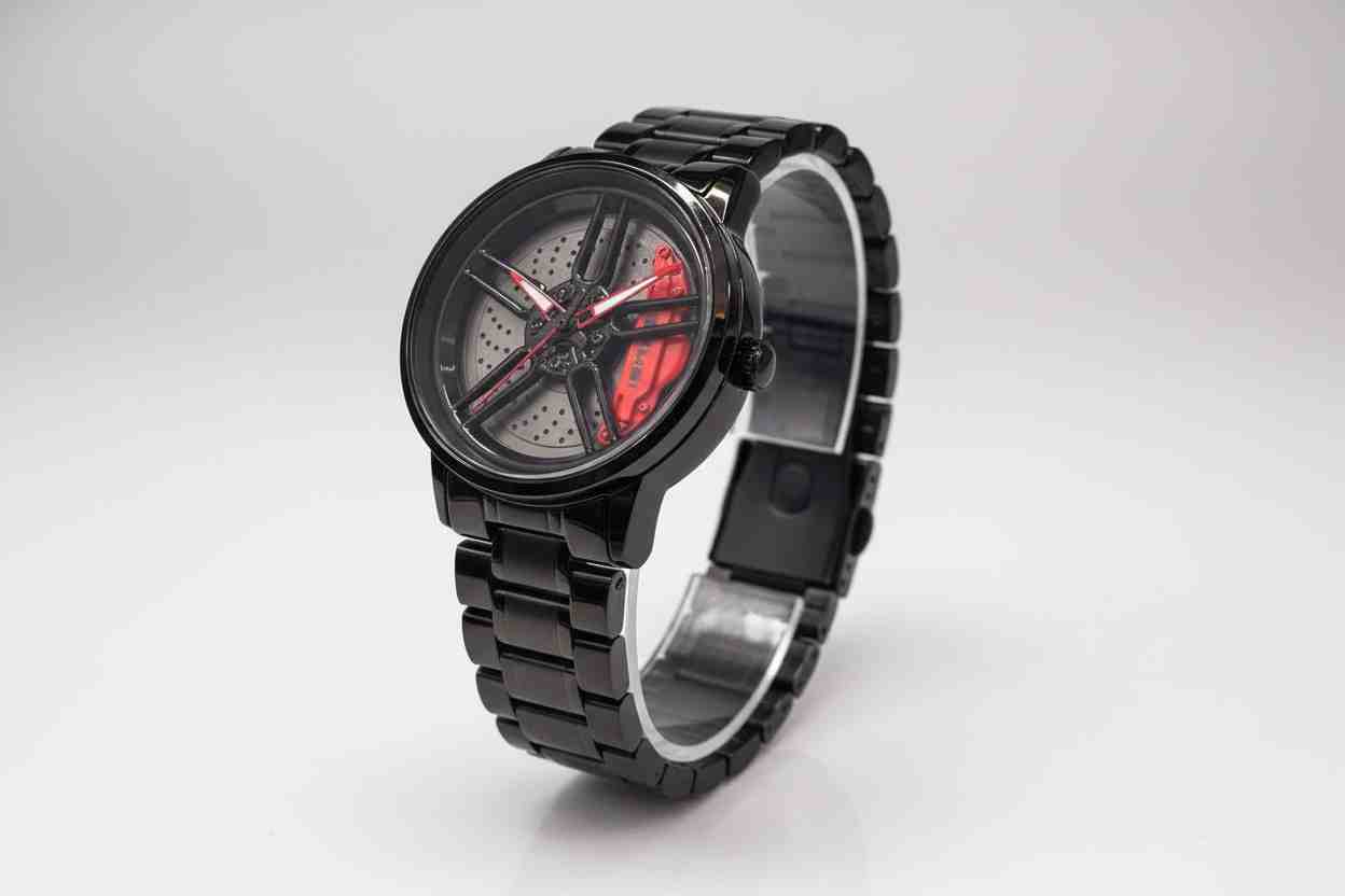 Reloj deportivo negro con diseño de llanta y detalles rojos