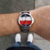 Reloj náutico con malla metálica plateada en la muñeca