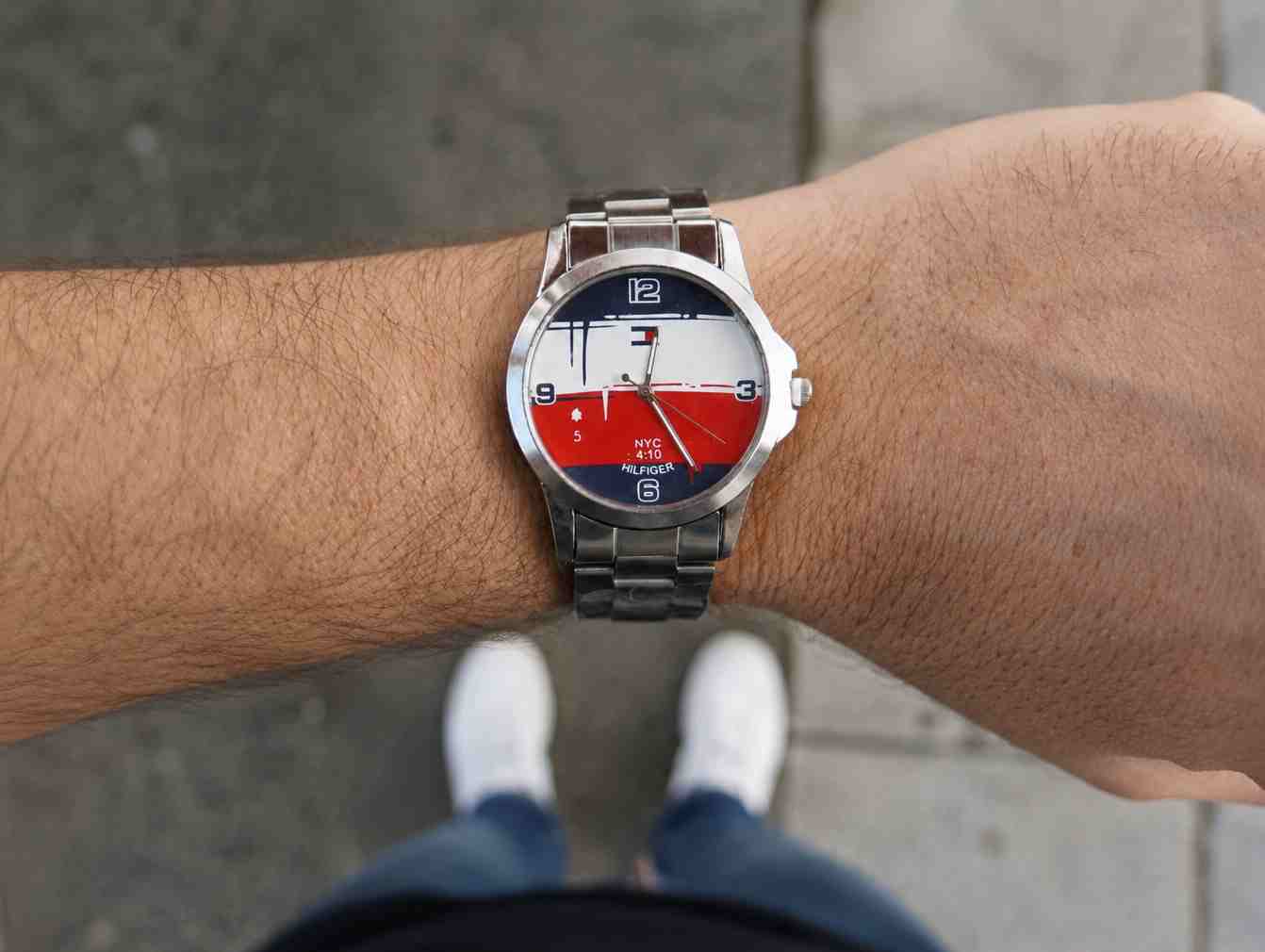 Reloj náutico con malla metálica plateada en la muñeca