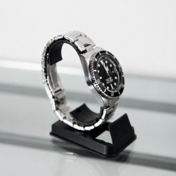 Reloj con bisel negro y malla metálica plateada