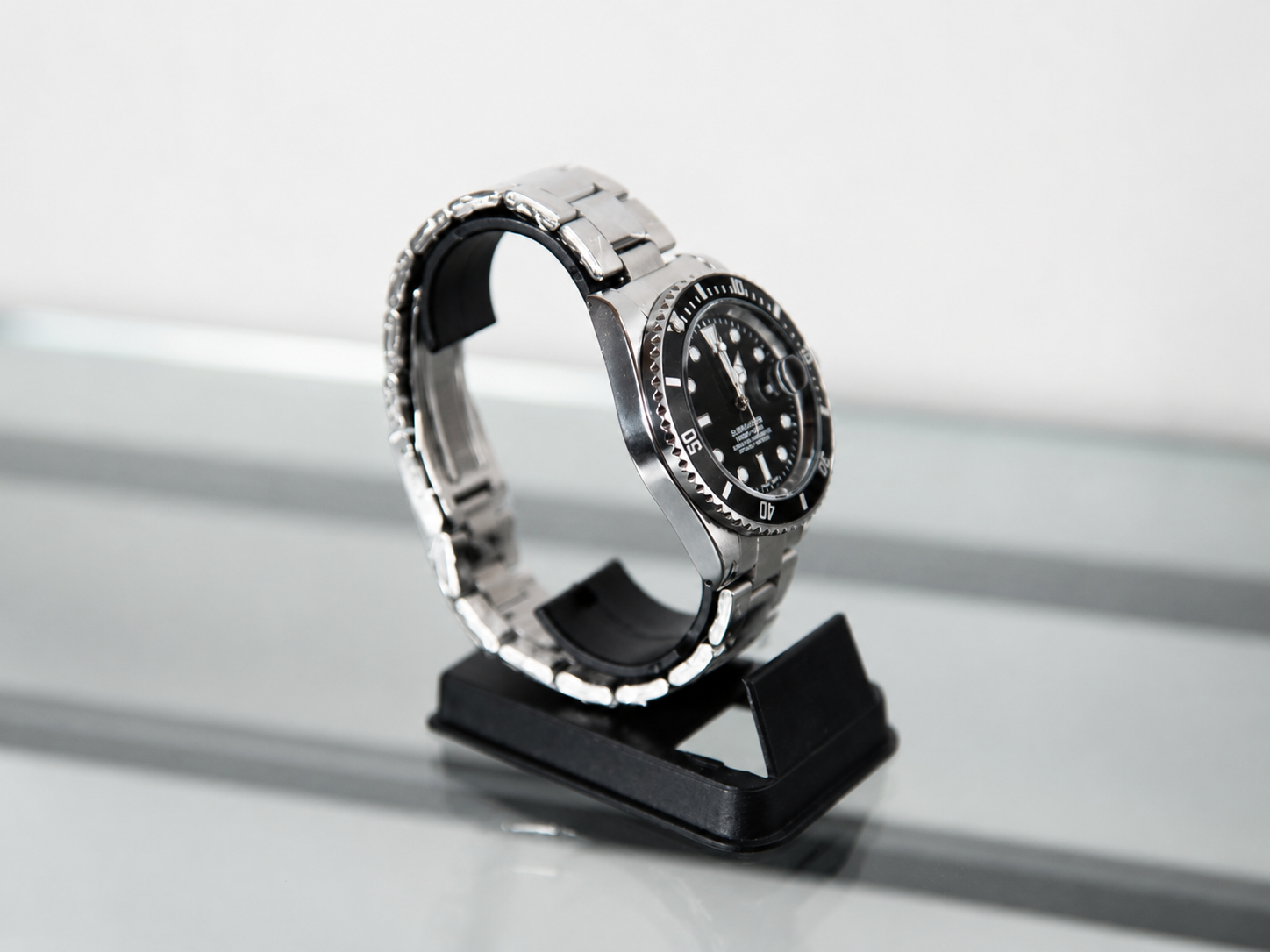Reloj con bisel negro y malla metálica plateada