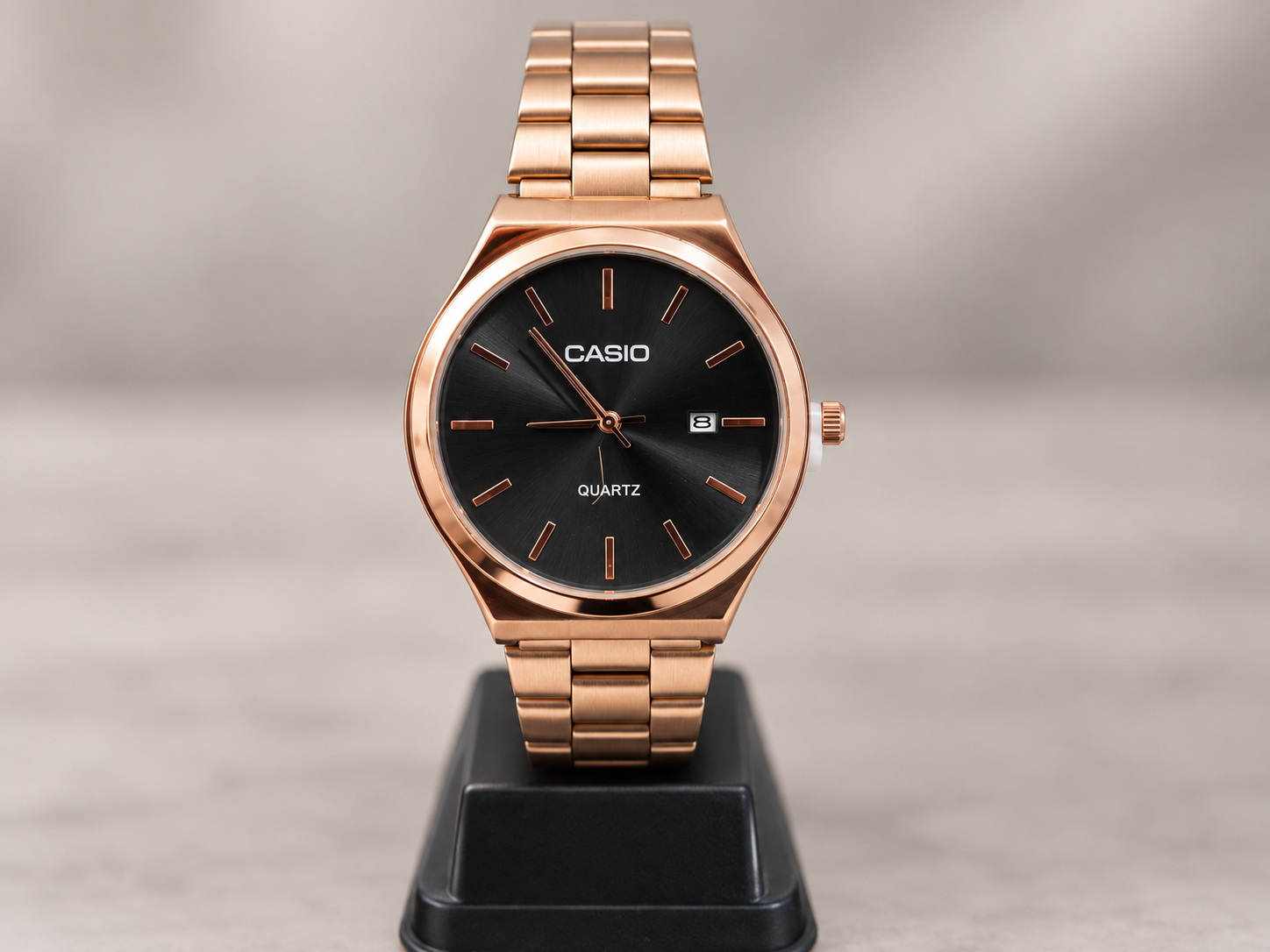 Cuatro relojes analógicos con malla metálica en tonos dorado y rosado, con esferas claras y negras.