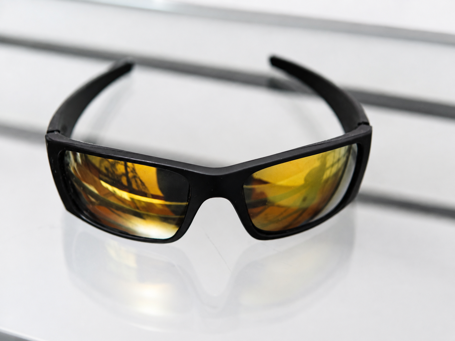 Anteojos de sol UV400 envolventes con marco negro y lentes ámbar vistos en perspectiva
