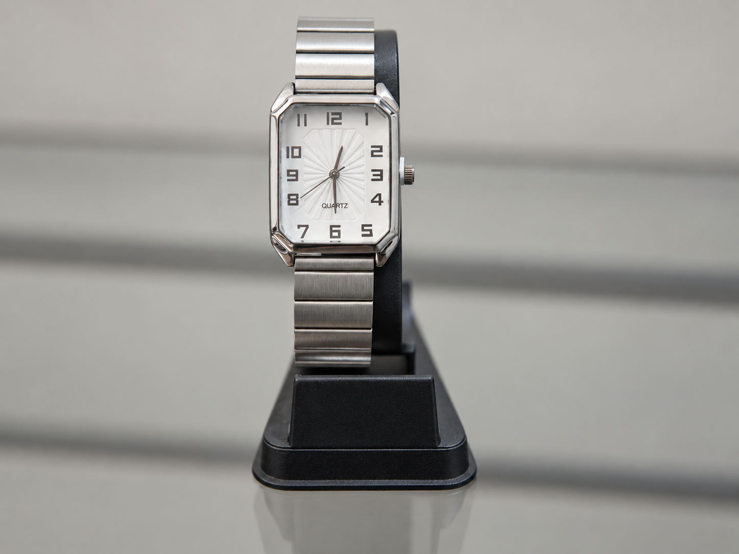 Reloj rectangular plateado con esfera blanca y números arábigos